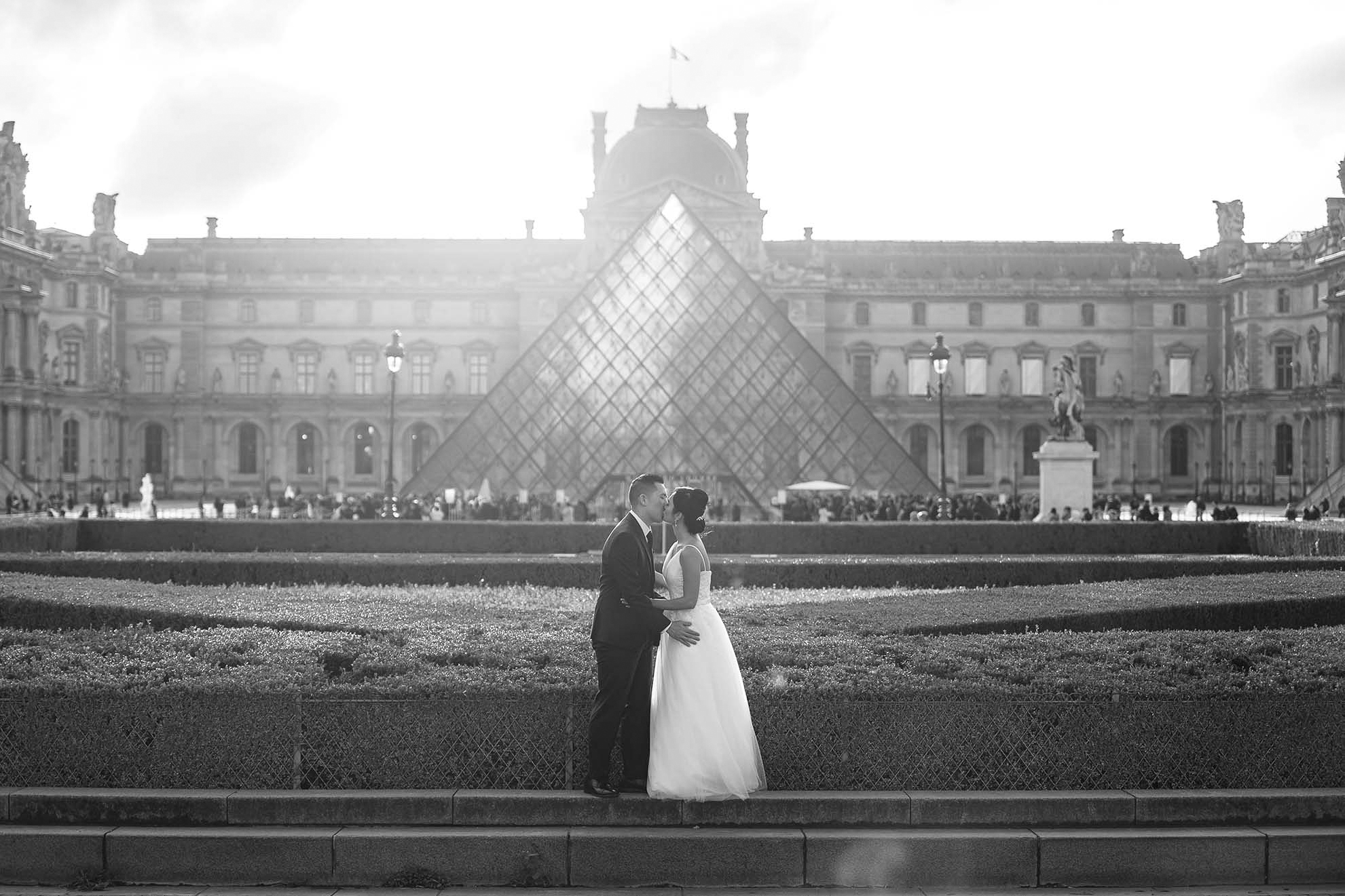 Newlyweds in front of the Louvre pyramid in Paris